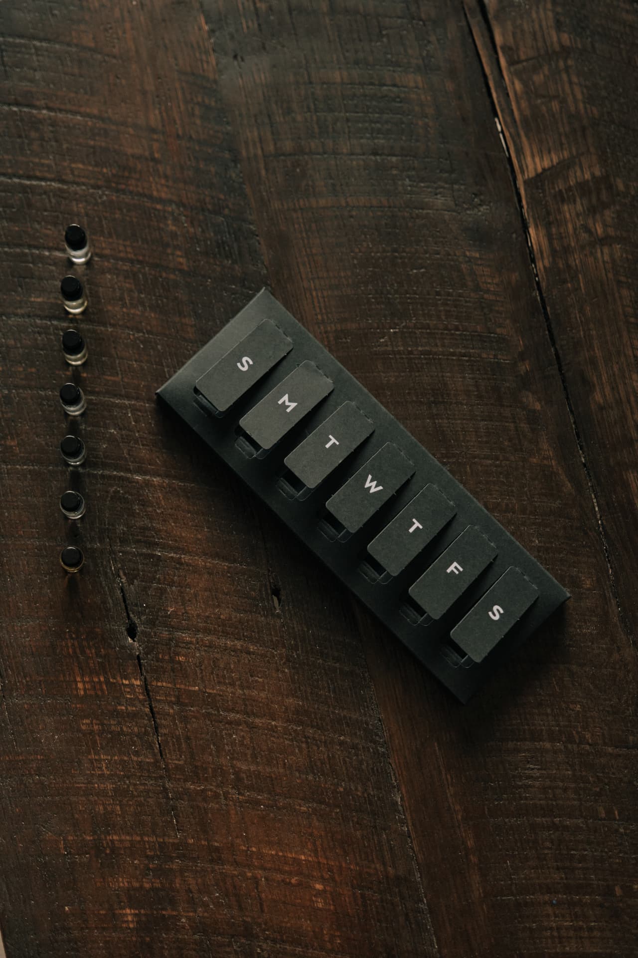 The seven-day Discovery Set sleeve labeled S M T W T F S beside a row of sample vials